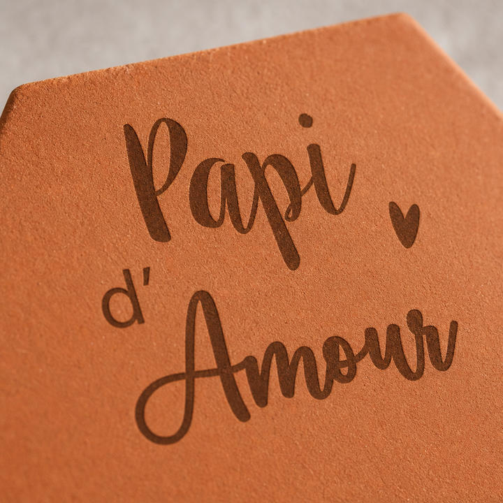 Gros plan sur les mots gravés « Papi d’Amour » et le petit cœur de la tomette.