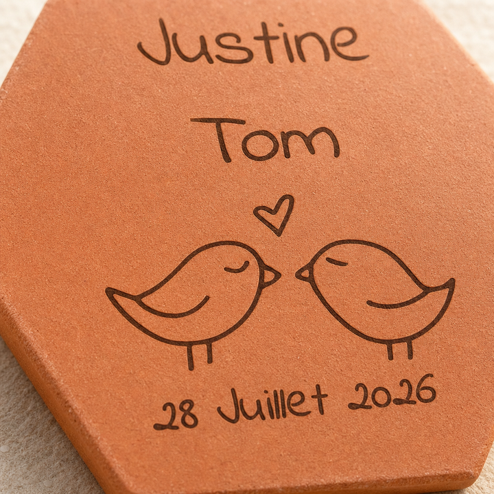 Gros plan sur les oiseaux face à face, le cœur et les prénoms gravés Justine et Tom.