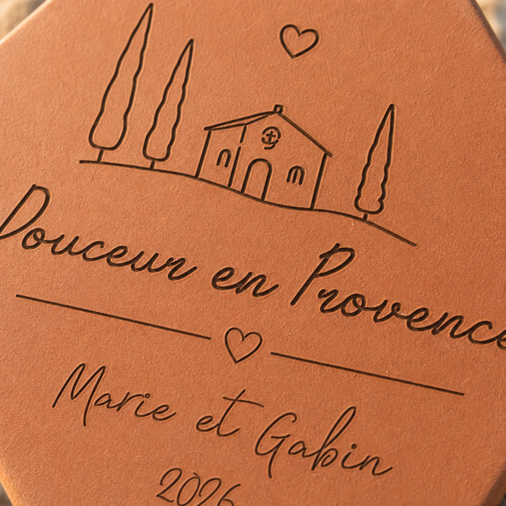 Détail de la maison, des cyprès et des prénoms Marie et Gabin gravés.