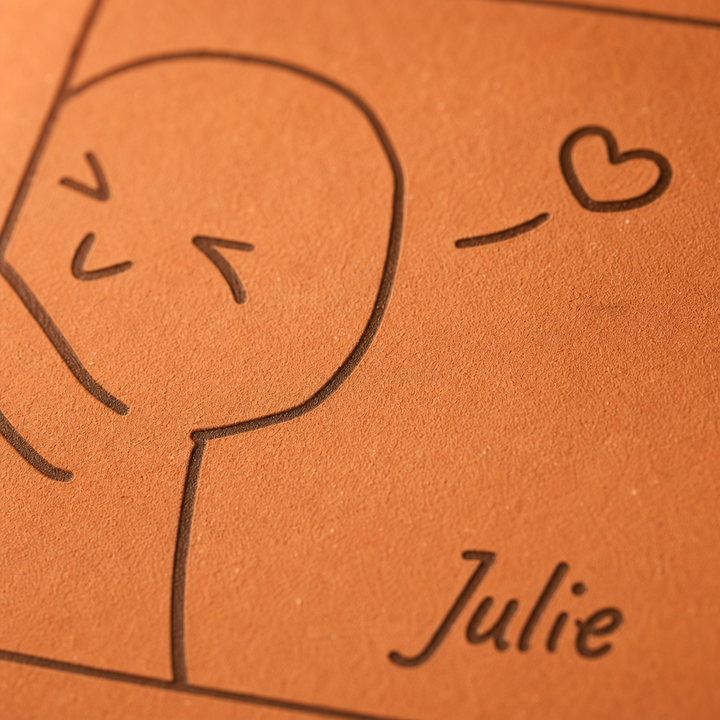 Gros plan sur la gravure laser : un personnage qui souffle un cœur et le prénom Julie.