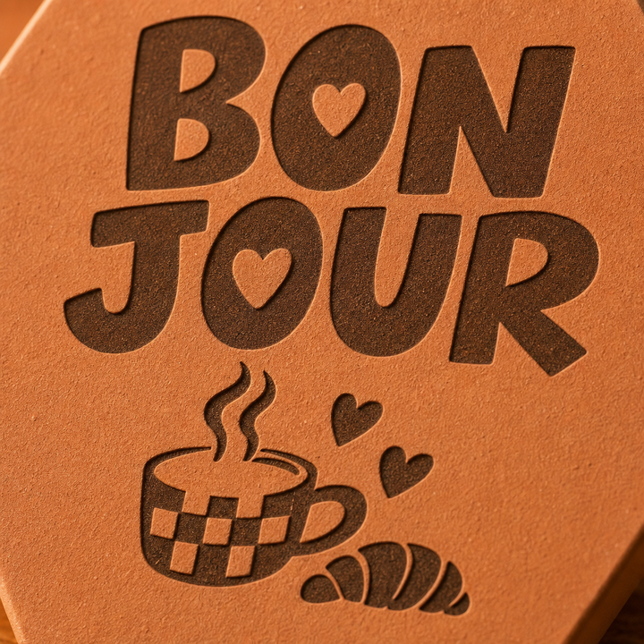 Gros plan sur Bonjour, la tasse fumante à carreaux, le croissant et les cœurs gravés.