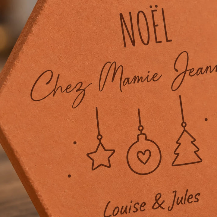 Détail des suspensions étoile, boule et sapin et du message Noël chez Mamie Jeanne gravés.