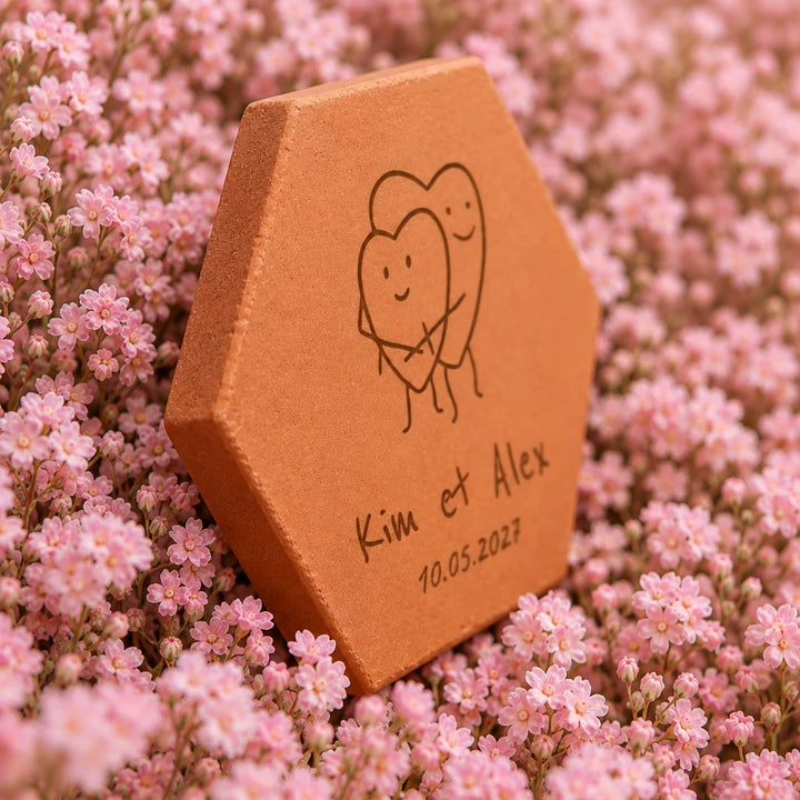Carreau décoratif Coeurs amoureux en terre cuite, posé sur des fleurs roses pastel. — vue de profil