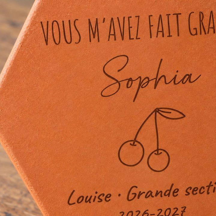 Tomette personnalisée Merci maîtresse, motif cerises, sur vieux bureau d’écolier avec dessin et crayons — vue rapprochée du motif
