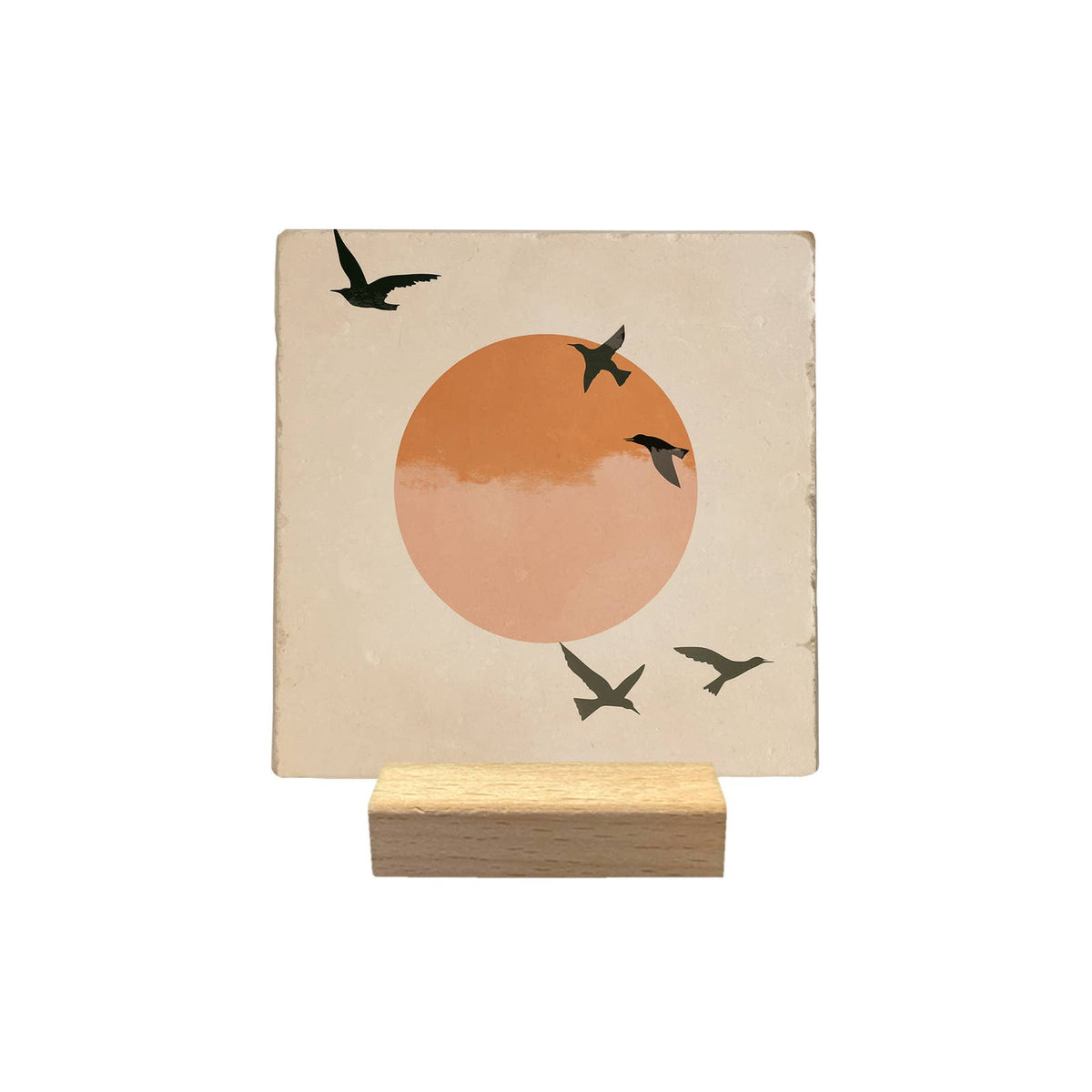 Carreau décoratif Oiseaux noirs, silhouettes en vol devant un soleil orangé, présenté sur un petit support en bois sur fond blanc.