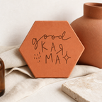 Cadeau de crémaillère : tomette hexagonale personnalisée en terre cuite de Salernes gravée au laser, ambiance pastel.