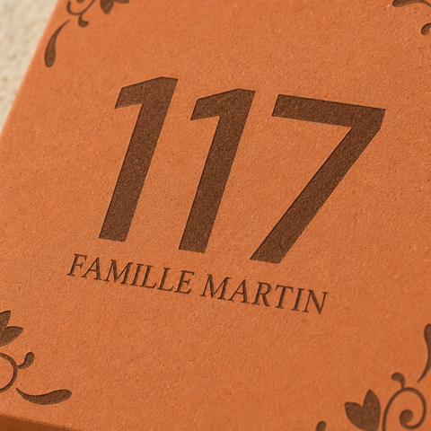 Gros plan sur le numéro 117 et le nom Famille Martin gravés sur le carreau.
