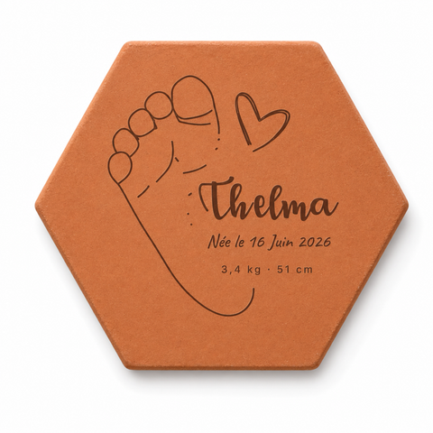 Tomette faire-part personnalisée Thelma, empreinte de pied et cœur gravés, sur fond blanc.
