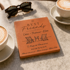 Carreau d’amitié personnalisé « Best Friends », trois prénoms, transats et lieu gravés, posé près de lunettes de soleil et d’une tasse de café.