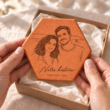Illustration de projection d’un cadeau photo personnalisé : une tomette gravée d’un couple, tenue dans les mains au-dessus d’une boîte.