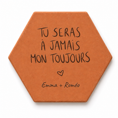Saint-Valentin, tomette hexagonale personnalisée en terre cuite de Salernes gravée au laser, tenue dans une main féminine.