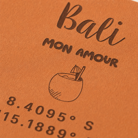 Gros plan sur la gravure Bali mon amour, la noix de coco et les coordonnées GPS.