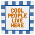 “Cool people live here” decorative tile, with orange lettering and a blue checked border, viewed from the front against a white background.