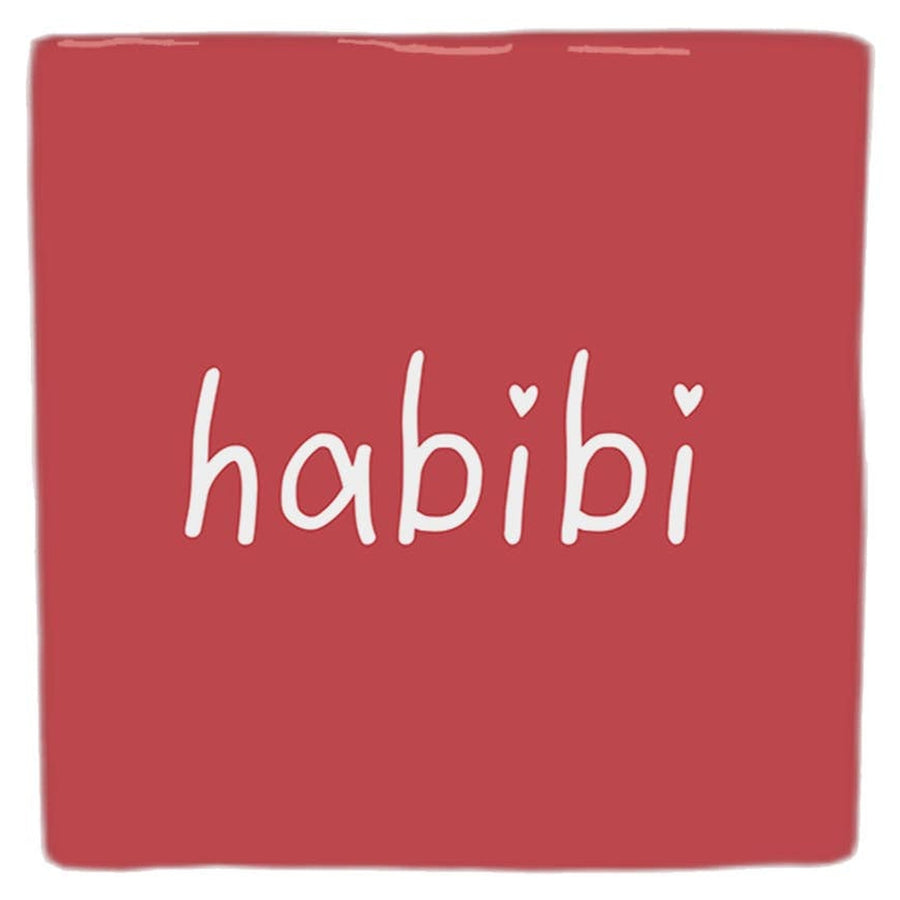 Carreau décoratif rouge « habibi », lettres blanches et petits cœurs, vu de face sur fond blanc.