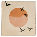 Carreau décoratif Oiseaux noirs, silhouettes en vol devant un soleil orangé, vu de face sur fond blanc.