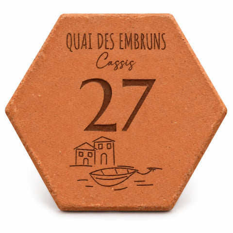 Personalised “Quai des Embruns, Cassis” house plaque, engraved with the number 27 and a small boat, on a white background.