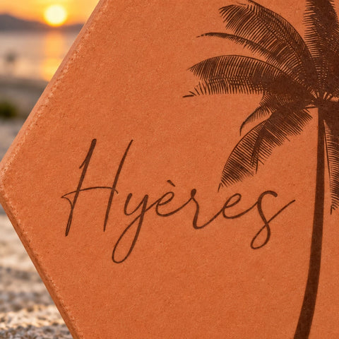 Détail de la gravure Hyères et des palmes sur la tomette, avec le soleil flou derrière.