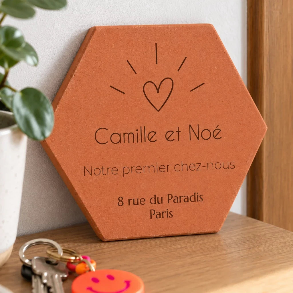 Detalle del grabado: los nombres Camille y Noé, el corazón y la dirección grabados.