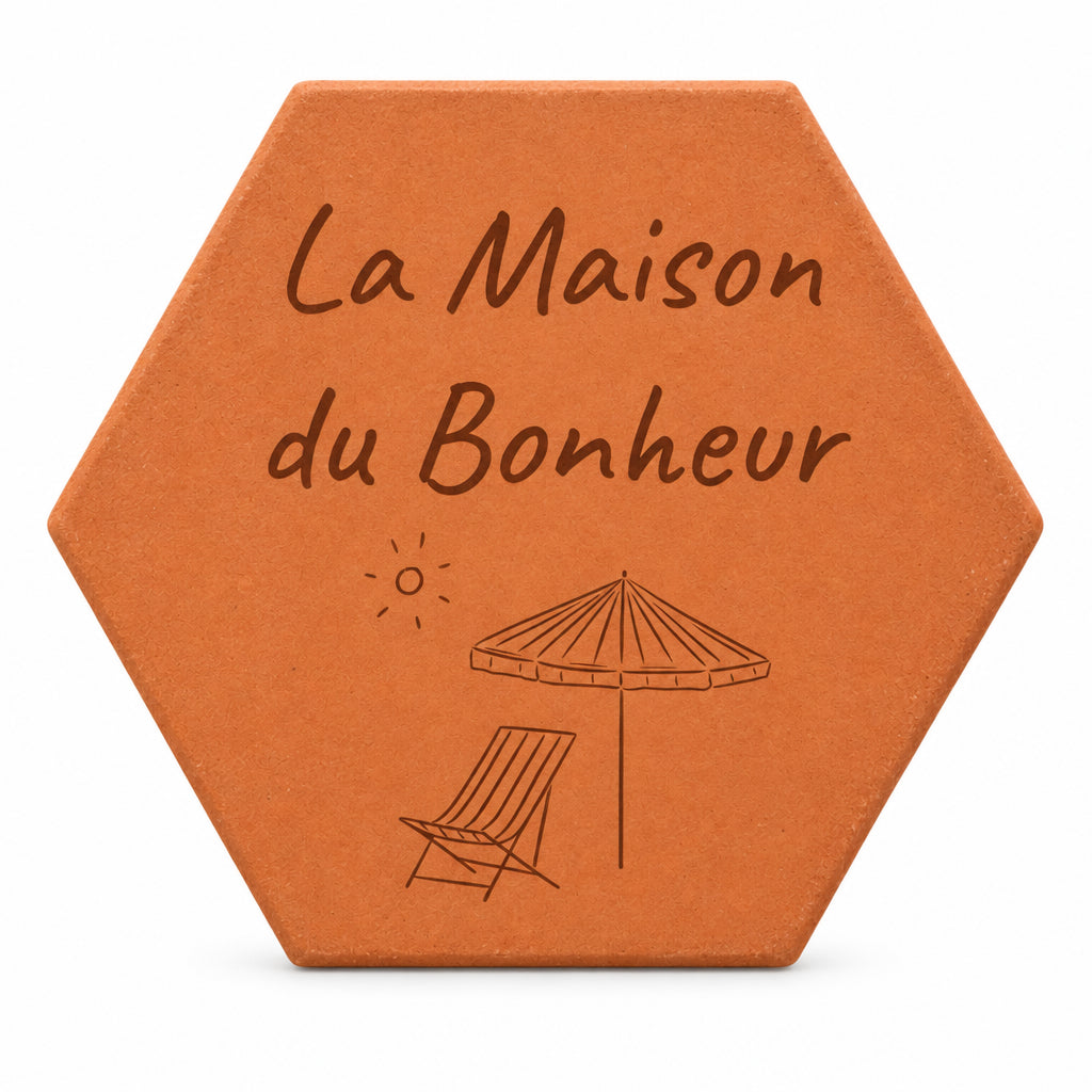 Cadeau de crémaillère porte-bonheur : tomette gravée « La Maison du Bonheur », parasol et chaise longue, sur fond blanc.