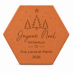 Tomette de Noël personnalisée « Joyeux Noël en famille », trois prénoms et sapins gravés, sur fond blanc.