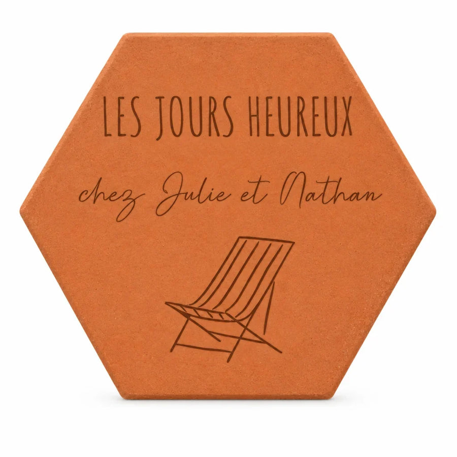 Cadeau pour une nouvelle maison : tomette « Les jours heureux chez Julie et Nathan » et chaise longue gravées, sur fond blanc.