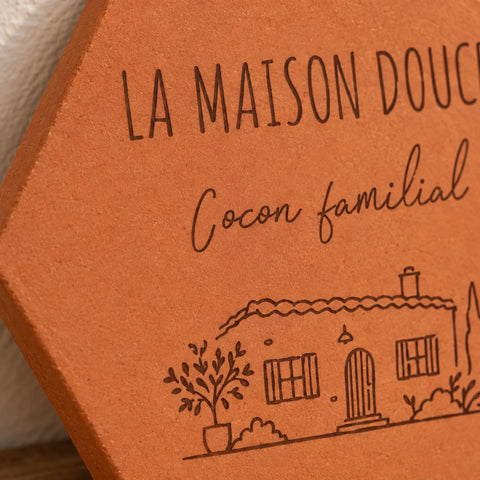 Gros plan sur les mots Cocon familial et la maison avec arbres gravés.