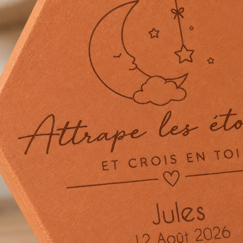 Détail de la lune, des étoiles et du prénom Jules gravés sur la tomette.