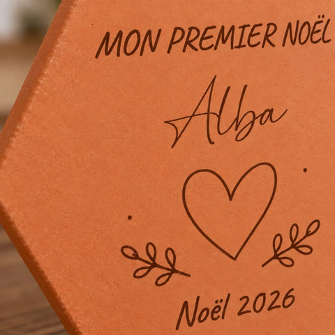 Gros plan sur le prénom Alba, le cœur entouré de brindilles et Noël 2026 gravés.