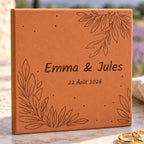 Carreau de mariage personnalisé Emma et Jules, date et feuillages gravés, vu de près, avec les brindilles dans les angles et les alliances au bord.
