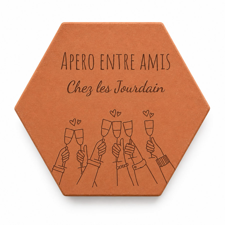 Cadeau de crémaillère entre amis : tomette « Apéro entre amis, Chez les Jourdain » et verres qui trinquent gravés, sur fond blanc.