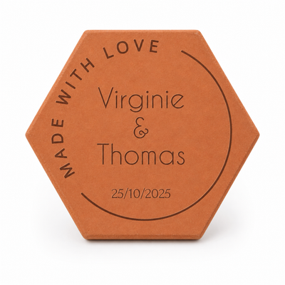 Photo romantique en chambre d’amoureux, tomette hexagonale personnalisée en terre cuite de Salernes gravée au laser pour mariage.