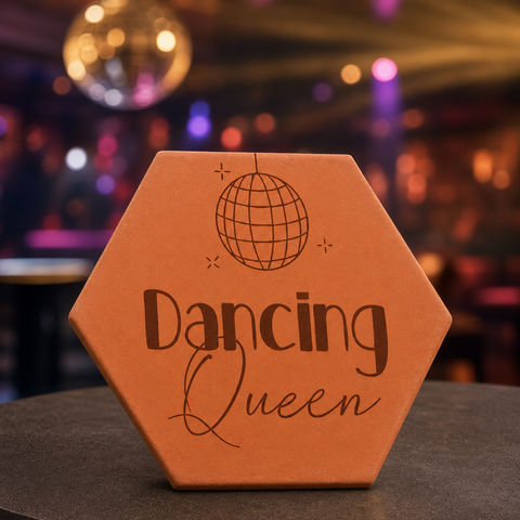 Tomette gravée « Dancing Queen » avec boule à facettes, devant des lumières colorées et une boule disco.