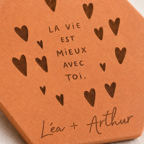 Gros plan sur les cœurs et le message La vie est mieux avec toi, avec Léa et Arthur gravés.