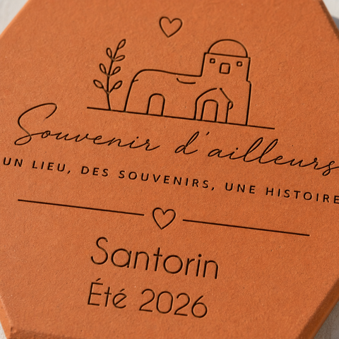 Gros plan sur la maison à coupole, le cœur et la destination Santorin gravés.