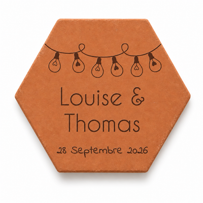 Mariage : tomette hexagonale personnalisée, terre cuite de Salernes gravée au laser, tenue dans une main de femme.