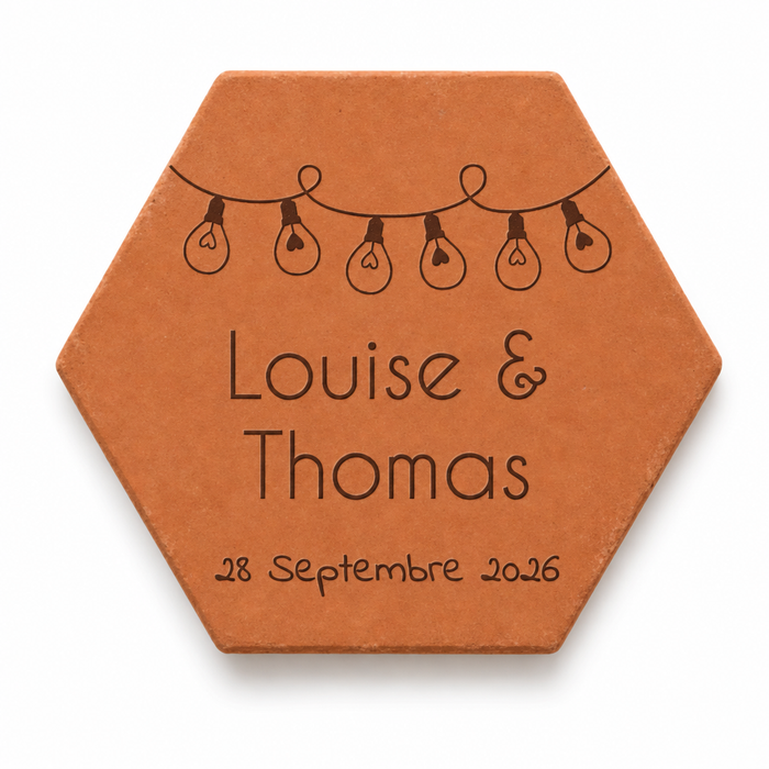 Mariage : tomette hexagonale personnalisée, terre cuite de Salernes gravée au laser, tenue dans une main de femme.