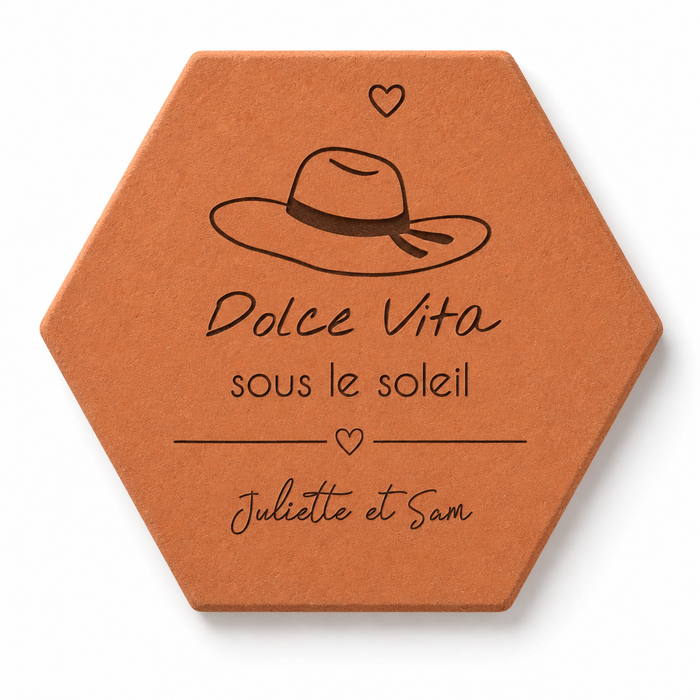 Cadeau souvenir de Provence, tomette hexagonale personnalisée en terre cuite de Salernes gravée au laser, en fond une place provençale.