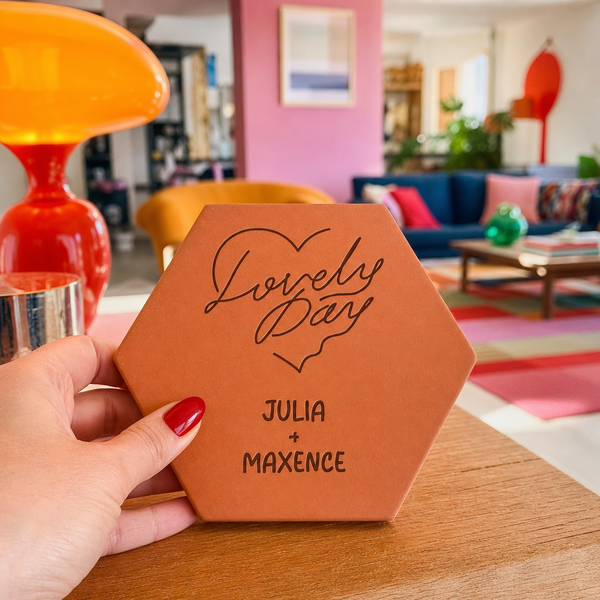 Saint-Valentin : tomette hexagonale personnalisée en terre cuite de Salernes gravée au laser, tenue par une main de femme.