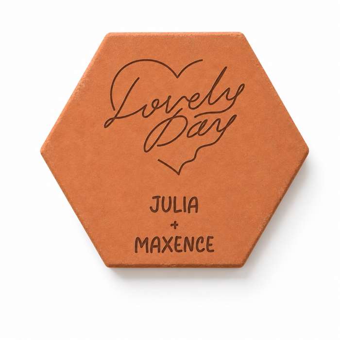 Saint-Valentin : tomette hexagonale personnalisée en terre cuite de Salernes gravée au laser, tenue par une main de femme.