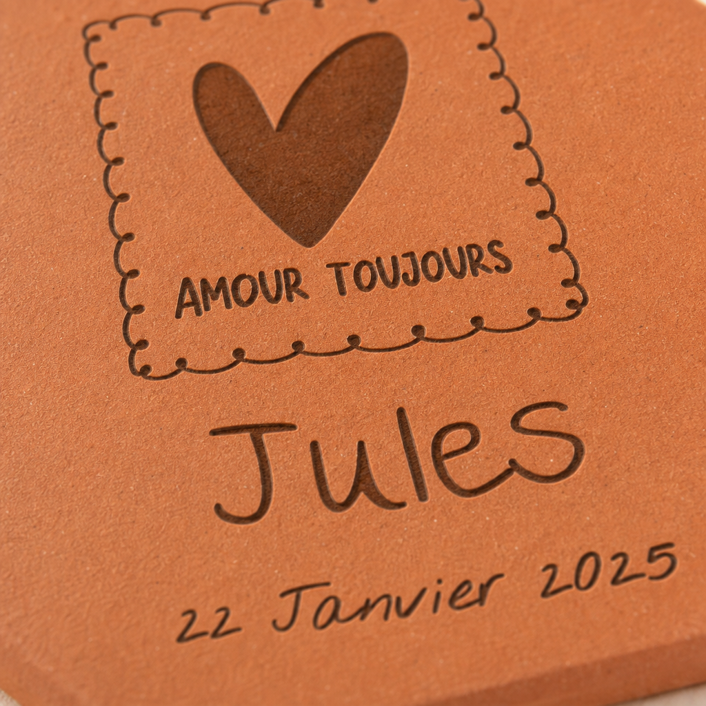 Naissance : tomette hexagonale personnalisée en terre cuite de Salernes gravée au laser, posée sur une table d'été solaire aux rayures jaunes.