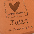 Naissance : tomette hexagonale personnalisée en terre cuite de Salernes gravée au laser, posée sur une table d'été solaire aux rayures jaunes.