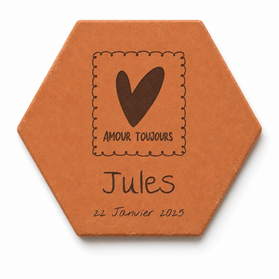 Naissance : tomette hexagonale personnalisée en terre cuite de Salernes gravée au laser, posée sur une table d'été solaire aux rayures jaunes.