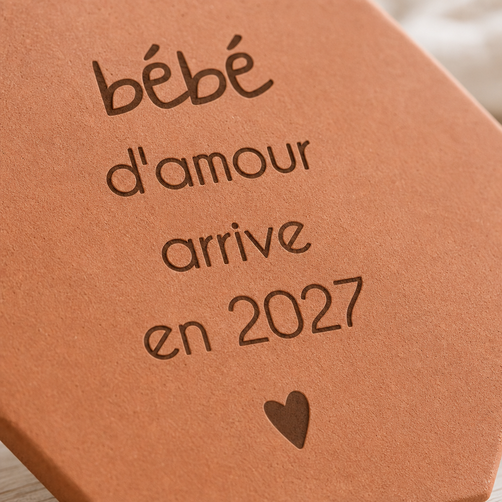 Annonce naissance : tomette hexagonale personnalisée, terre cuite de Salernes gravée au laser, en mains lors d'une fête de famille.