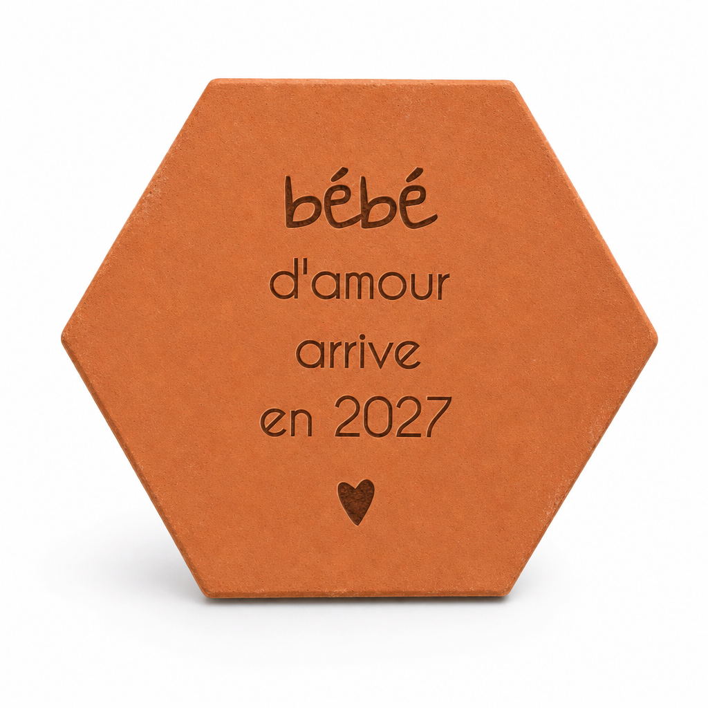 Annonce naissance : tomette hexagonale personnalisée, terre cuite de Salernes gravée au laser, en mains lors d'une fête de famille.