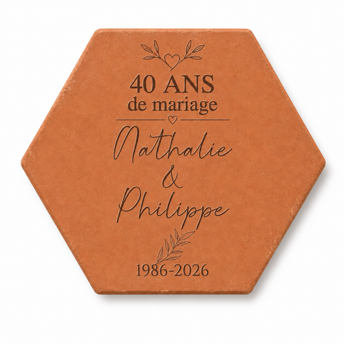 Pieza hexagonal de terracota grabada con «40 ans de mariage», hojas, Nathalie & Philippe y «1986-2026», sobre fondo blanco.