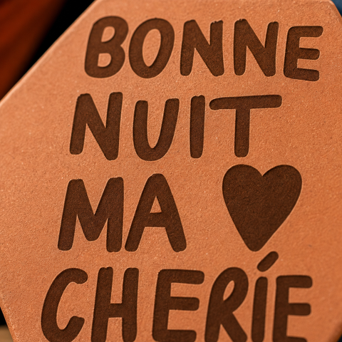 Gros plan sur les lettres Bonne nuit ma chérie et le cœur gravés.