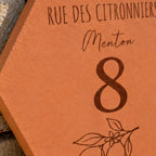 Detail of the engraved number 8, “Menton” and lemon branch.
