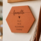 Tomette personnalisée « famille », cœur et quatre prénoms gravés, vue de près sur le mur de l’entrée.