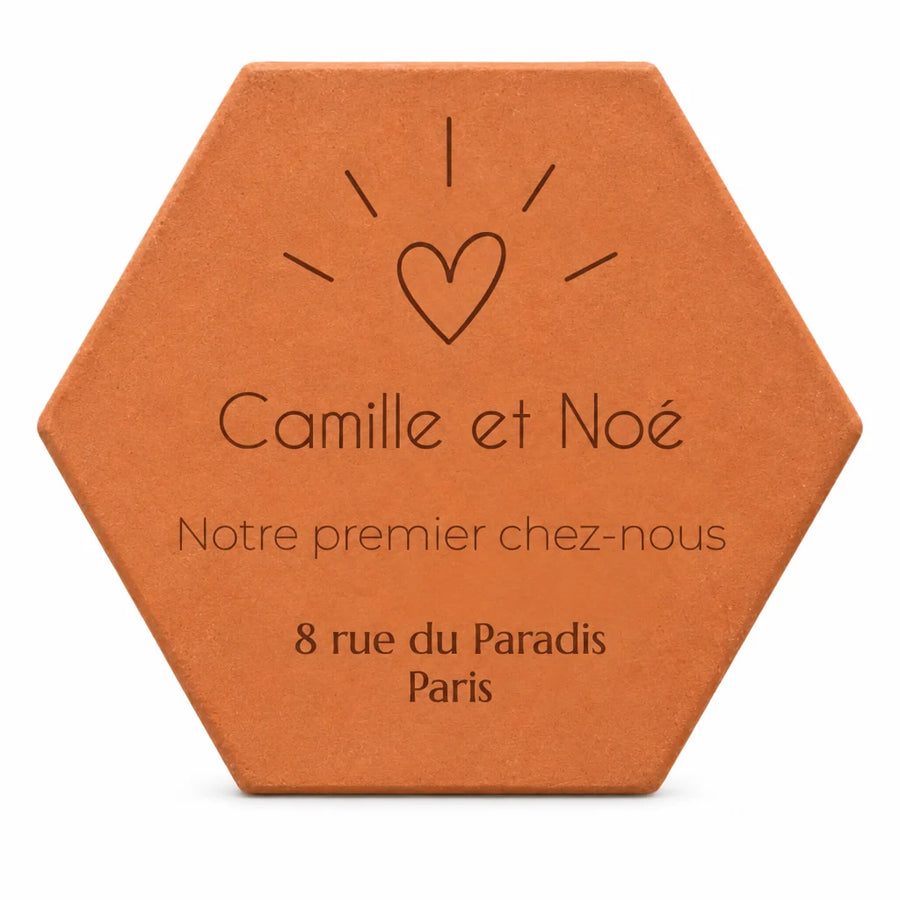 Cadeau de crémaillère pour un couple : tomette « Notre premier chez-nous », Camille et Noé, cœur et adresse gravés, sur fond blanc.