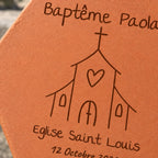 Tomette personnalisée Baptême - Eglise, posée dans les mains d’une enfant, avec église et lavande en arrière-plan — vue rapprochée du motif